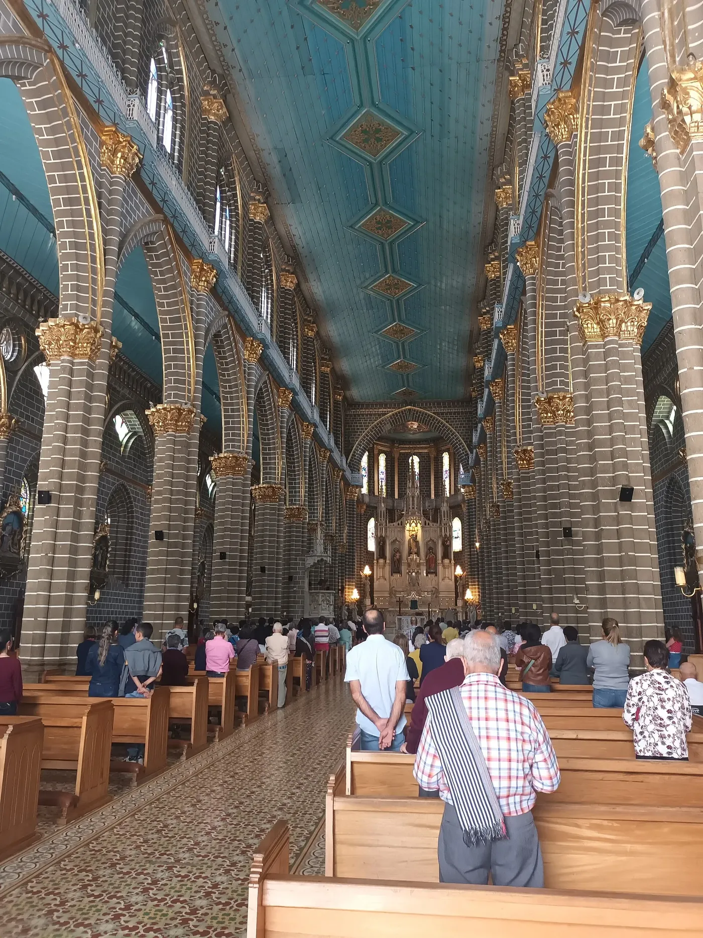 Nave central de la basílica de Jardín con su techo azul y arcos