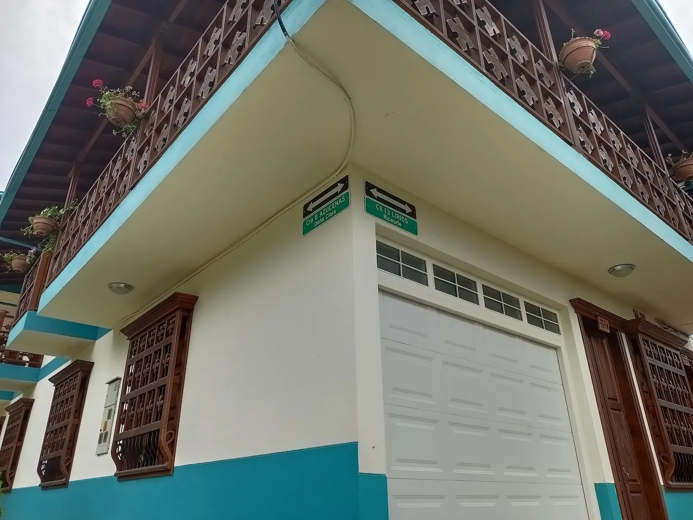 Fachada blanca con puertas y ventanas de colores en Jardín
