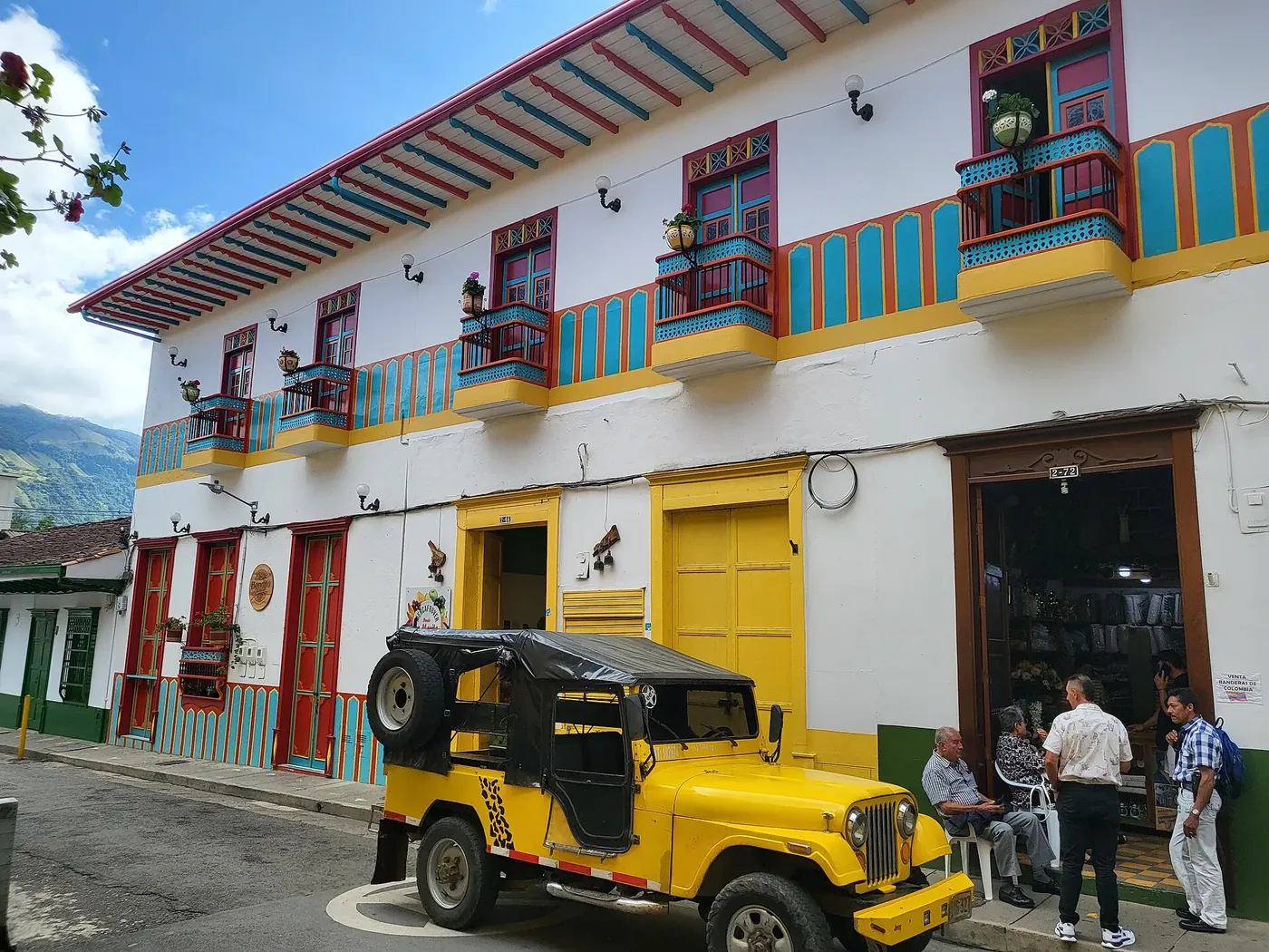 Jeep Willys amarillo estacionado frente a casas de colores en Jardín
