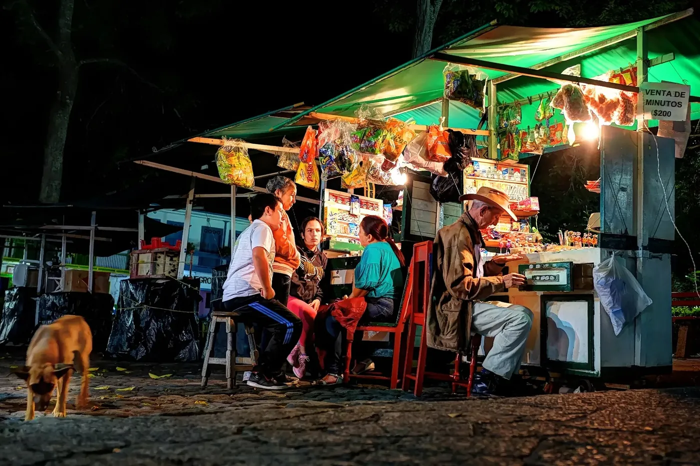 Tiendas iluminadas en una esquina de Jardín de noche